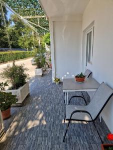 a patio with a bench and a table and potted plants at Kostic Apartments in Buljarica