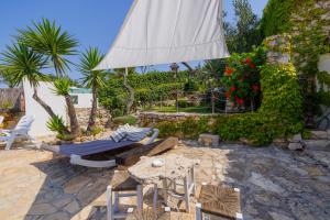 a patio with a table and chairs and an umbrella at Villa Paiare in Torre Vado