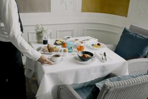 a man standing next to a table with food on it at Parkhotel Laurin in Bolzano