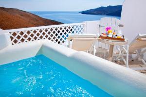 a pool on a balcony with a table and chairs at Tholaria Boutique Hotel in Astypalaia Town