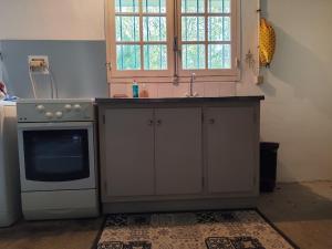 a kitchen with a sink and a stove at Jolie chambre indépendante avec salle d'eau privée in Mornac