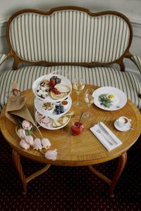 a wooden table with plates of food on it at Parkhotel Laurin in Bolzano