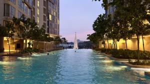 una piscina en una ciudad con gente nadando en ella en Balcony Unit @ Robertson Residence 18f, en Kuala Lumpur