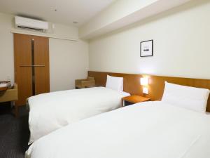 Dormy Inn Kanazawa Natural Hot Spring客房内的一张或多张床位
