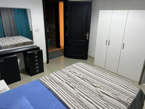 Pokój z łóżkiem, lustrem i drzwiami w obiekcie Luxury apartment in rehab city w mieście New cairo