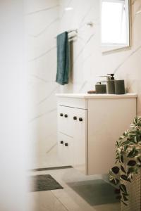 a white bathroom with a sink and a window at Sunrise Beach Apartments in Larnaka +35 photos