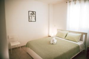 a bedroom with a bed with a teddy bear on it at Sunrise Beach Apartments in Larnaka