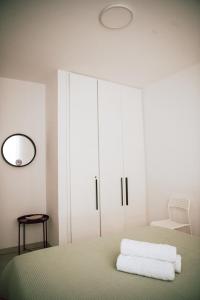 a white bedroom with a bed and a mirror at Sunrise Beach Apartments in Larnaka