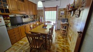 a kitchen with a table and chairs and a refrigerator at La casa di nonna Carmelina in Milazzo
