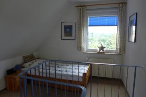 ein Schlafzimmer mit Kinderbett und Fenster in der Unterkunft Ferienwohnung Parkresidenz in Goslar