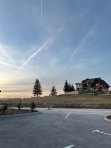 弗拉西克Apartmani BIR-Bee Vlašić的一个空的停车场,后面有房子