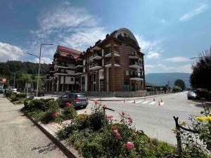 a building with a car parked in front of a street at Apartman Zen Fojnica in Fojnica
