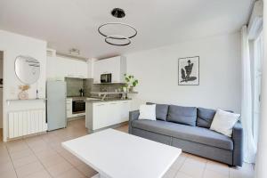 a living room with a couch and a kitchen at Le 17 - Super logement Proche Disney - Jardin in Torcy +4 photos