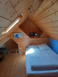 1 dormitorio con 1 cama en un ático de madera en Le panoramique, en Campan