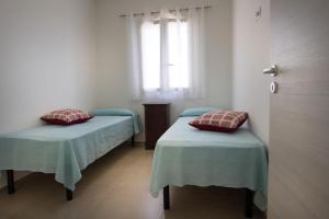 una stanza con due letti e una finestra di Casa Relax Torre Pali a Torre Pali