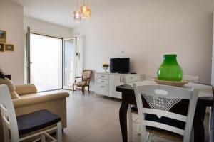 un soggiorno con tavolo e vaso verde di Casa Relax Torre Pali a Torre Pali