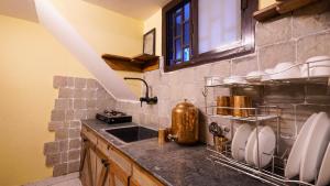 a kitchen with a sink and a counter with dishes at Aavya Wellness Retreat Center in Rishīkesh