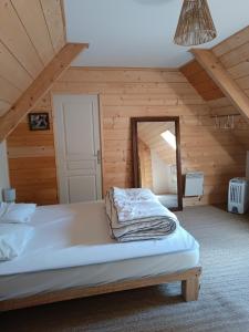 Un dormitorio con una cama en una habitación de madera. en Le panoramique, en Campan