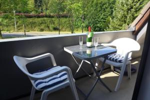 einen kleinen Tisch und Stühle auf einem Balkon mit Fenster in der Unterkunft Ferienwohnung Parkresidenz in Goslar