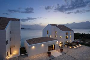 zwei weiße Gebäude mit Blick auf das Wasser in der Unterkunft Hotel Vallum by St Pietro in Cavtat