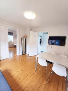 Una sala de estar con una mesa y sillas blancas. en 1 Bedroom Apartment In Frederikshavn City With Free Parking, en Frederikshavn