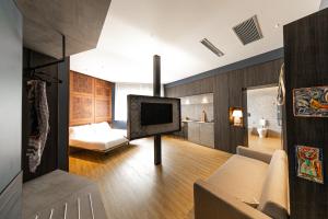 a living room with a tv on a pole at Nooria Sicilian Charme Rooms in Cefalù