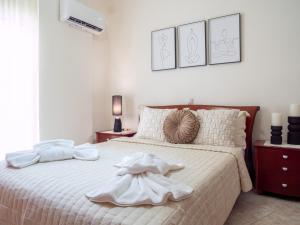 a bedroom with a white bed with a dress on it at Rena's House in Ierapetra
