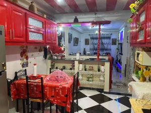 a kitchen with red cabinets and a red table with chairs at Location Appartement Cherchell Algérie Tipaza in Bois Sacré