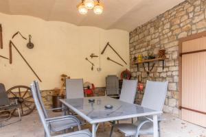 a table and chairs in a room with a stone wall at Wohnung für 8 Personen in ehemaligem Weingut mit 4 Schlafzimmern in Rommersheim
