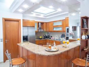 a kitchen with wooden cabinets and a counter with chairs at Rena's House in Ierapetra