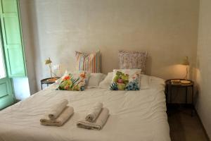 a white bed with two pairs of towels on it at I Pizzuti in Noto
