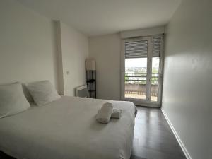 a bedroom with a bed with two towels on it at A 500m Paris, 130m2 avec 4ch, balcon et parking in Le Kremlin-Bicêtre