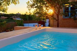 爱琴娜岛Leonti Maison的游泳池,提供两杯葡萄酒
