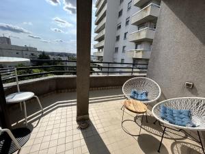 a balcony with chairs and tables on a building at A 500m Paris, 130m2 avec 4ch, balcon et parking in Le Kremlin-Bicêtre
