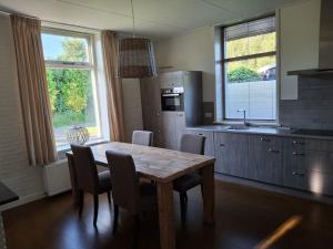 a kitchen with a wooden table and some chairs at Vakantieverblijf in Wijnbergen in Wijnbergen