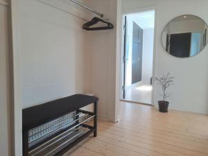 a living room with a black bench and a mirror at Centralt beliggende hyggeligt byhus med 8 sovepladser 130m2 med pejs in Holstebro