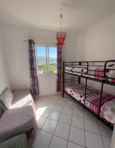 a bedroom with two bunk beds and a window at Appartement bord de mer in Jbila