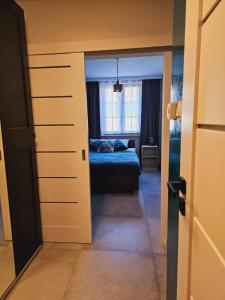 ein Zimmer mit einem Bett und einer Tür, die zu einem Schlafzimmer führt in der Unterkunft Kryształ A10, Garaż in Karpacz