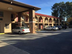 a parking lot in front of a building with cars parked at Perimeter Inn - Athens in Athens