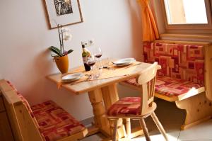 Una mesa con una botella de vino y dos copas. en Platterhof, en Avelengo