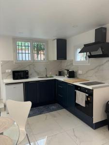 a kitchen with blue cabinets and white counter tops at Le petit moret in Joinville-le-Pont
