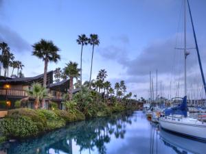 a river with boats docked next to houses and palm trees at Humphreys Half Moon Inn in San Diego