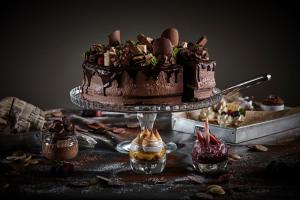 a chocolate cake on a table with other desserts at Hotel Astoria Playa Adults Only 4* Sup in Port d'Alcudia