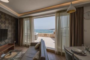 a dining room with a table and a large window at DuplexPenthouse seafront with hot tub by Homely in St. Paul's Bay