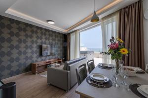 a dining room with a table and a room with a view at DuplexPenthouse seafront with hot tub by Homely in St. Paul's Bay