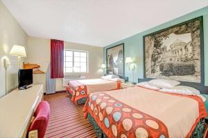 a hotel room with two beds and a television at Super 8 by Wyndham San Antonio/Fiesta in San Antonio