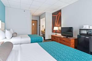 拉皮德城Elevation Inn & Suites, Trademark Collection by Wyndham的一间有两张床和一台平板电视的酒店房间
