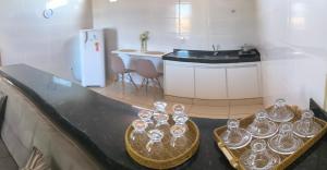 a counter top with a bunch of glass dishes on it at Apartamento completo in Montes Claros