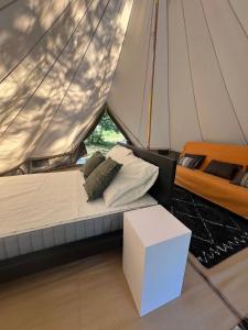 a bed on a sailboat with a white table and a box at Camping la Kahute - Tente lodge au coeur de la forêt in Carcans +49 photos