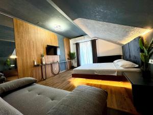 a bedroom with a bed and a couch in it at Prestige House Delux in Curtea de Argeş